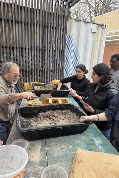 David Thaddeus and students mixing mud for bricks