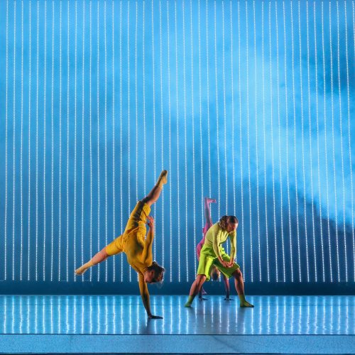 two dancers in front of blue striped LED screen
