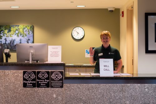 student waving at will call