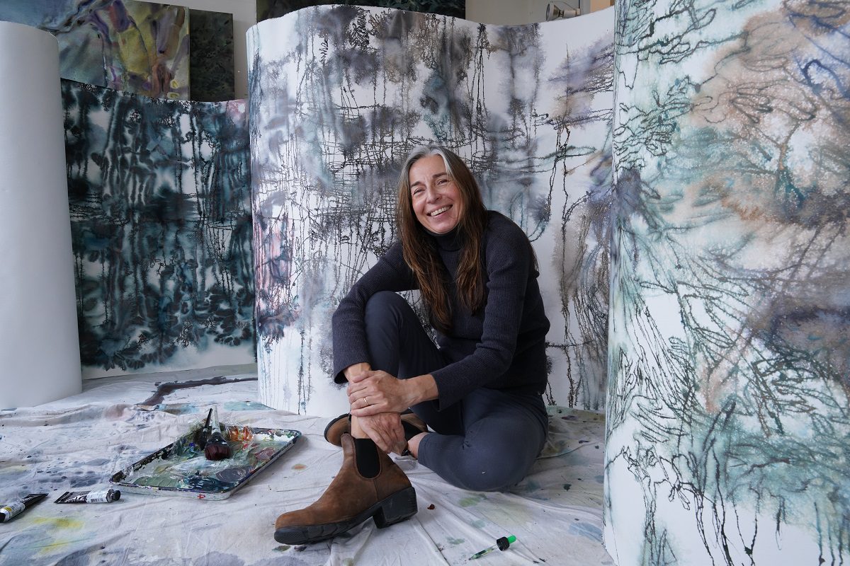 Maja Godlewska sitting among her watercolor scrolls