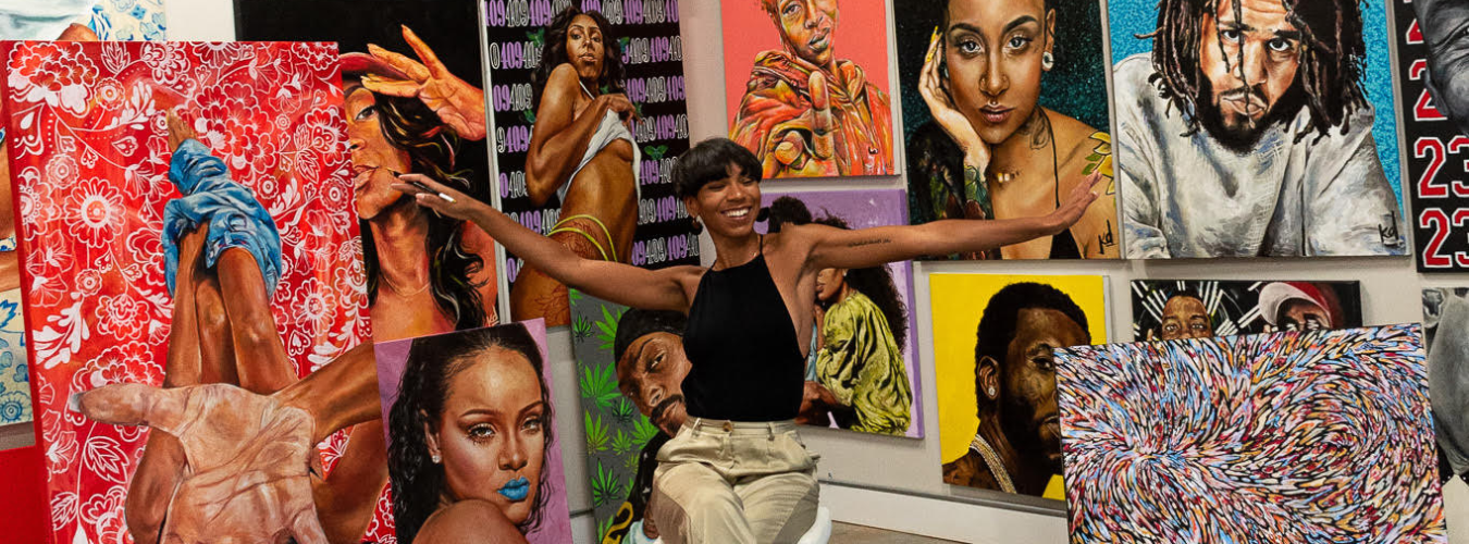 Kalin Devone in front of her artwork hanging on a wall