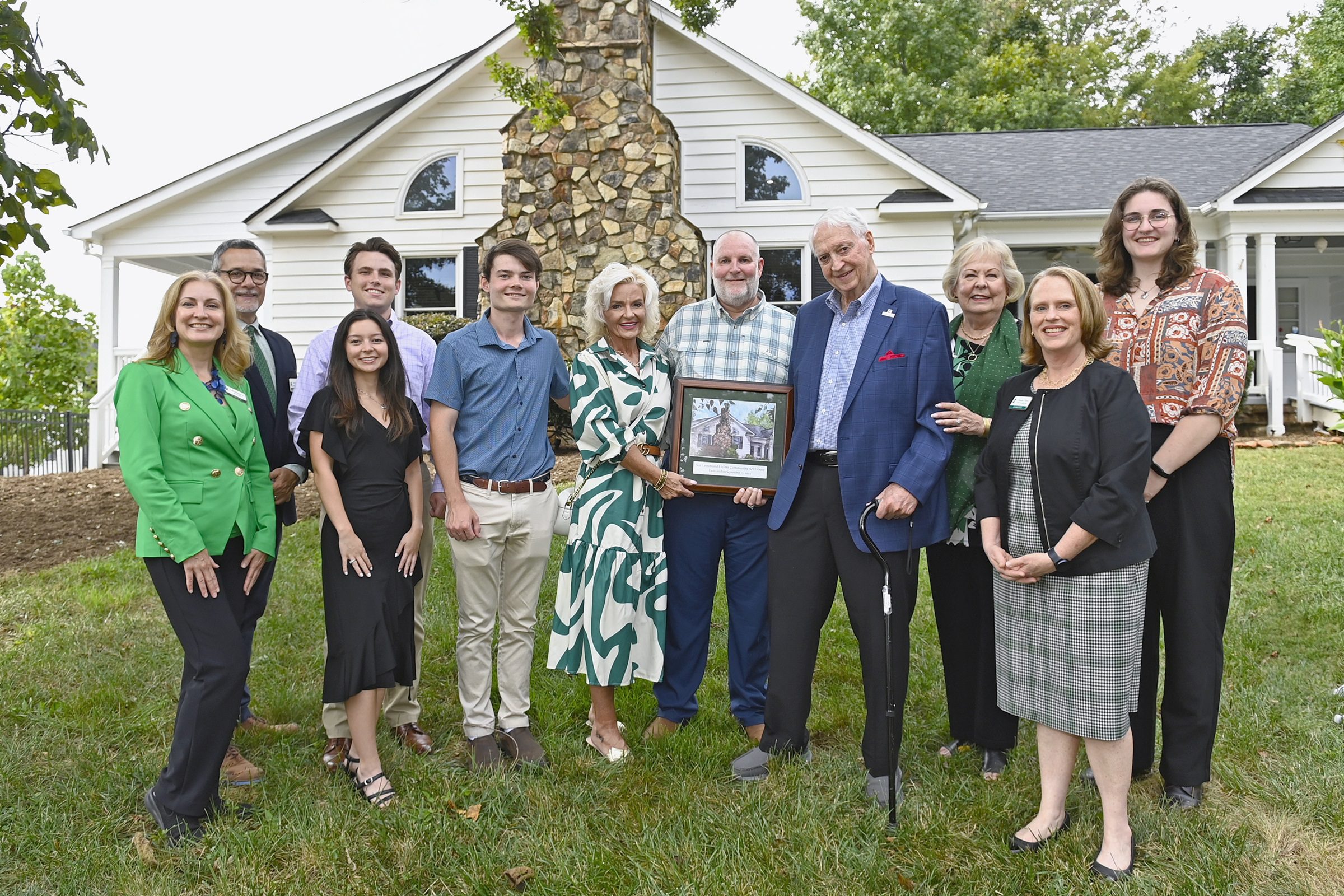 Helms family with provost, dean, and art department chair in front of the house.