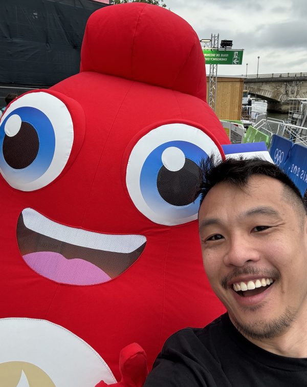 Matthew Gin in Paris with red character (Phyrges) at opening ceremony of the Olympics.