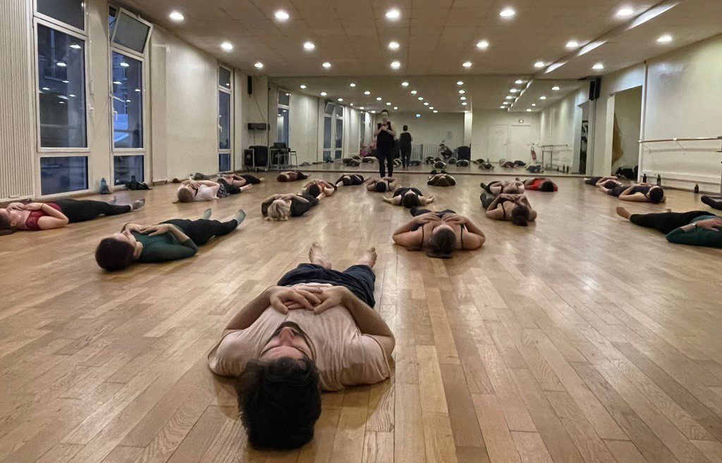 Kim Jones teaching a dance class, with students lying on floor