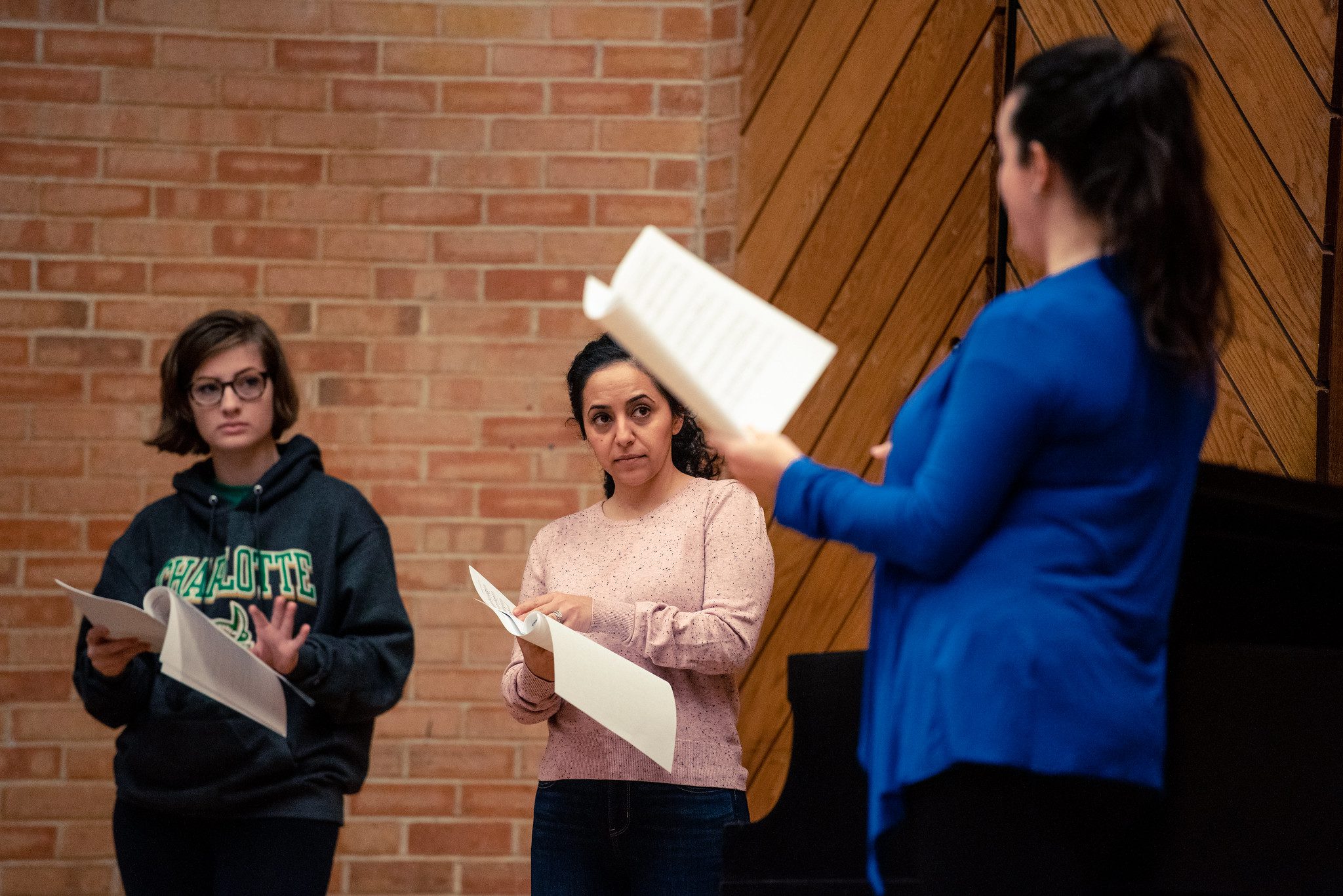 teacher and students on stage with music sheets