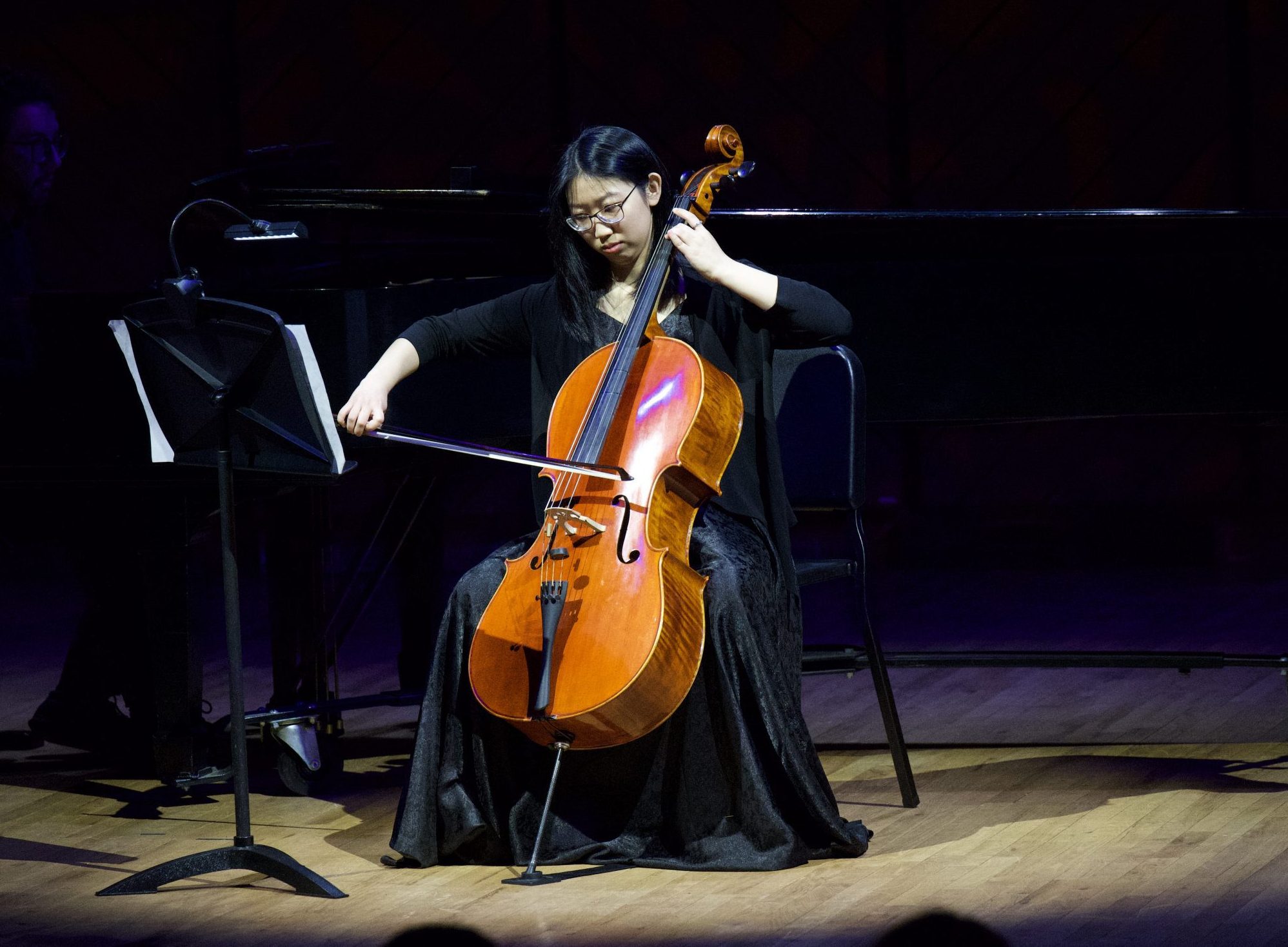 student performing with a cello on stage