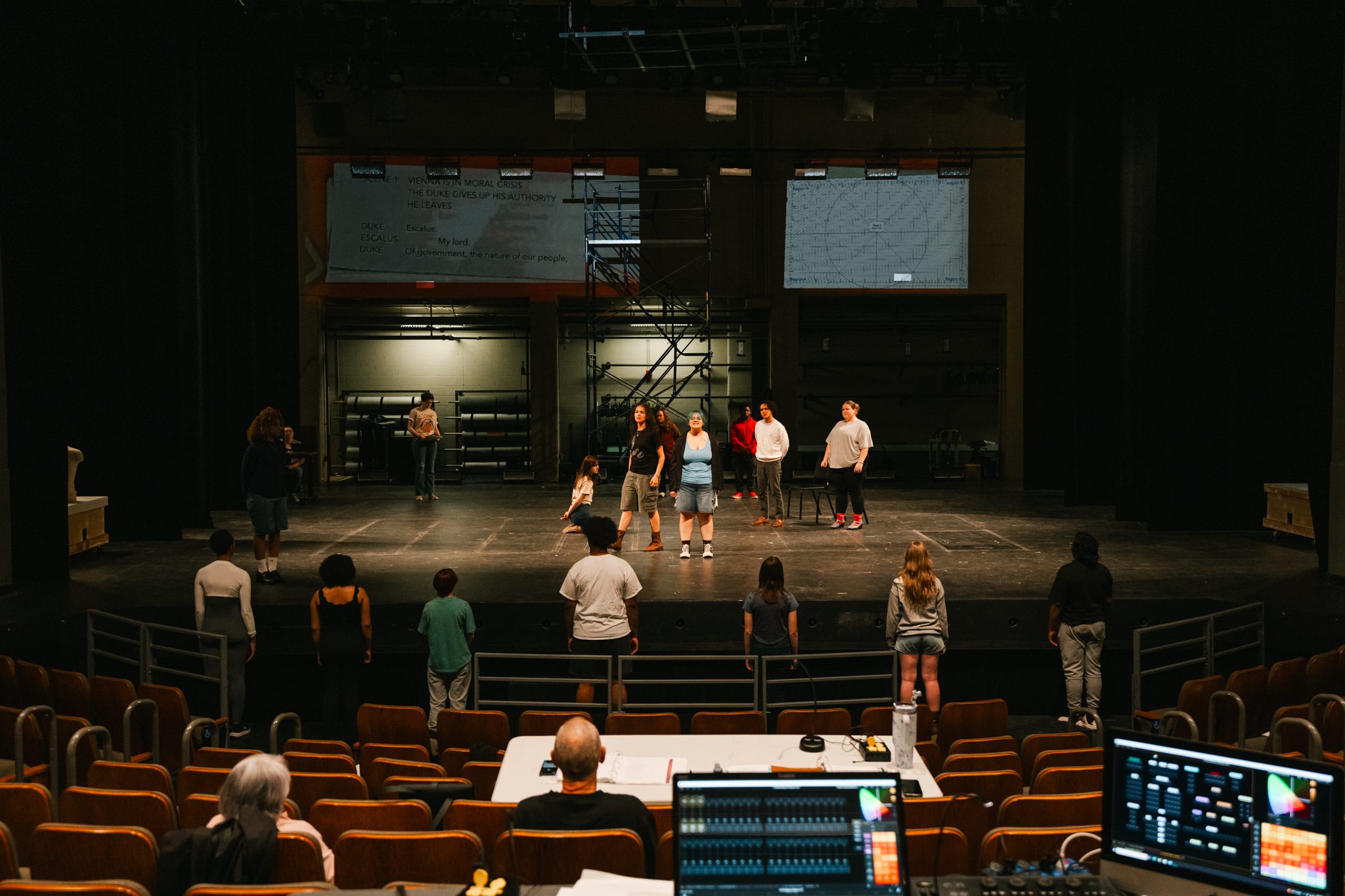 full view of the stage with students rehearsing, taking from audience perspective