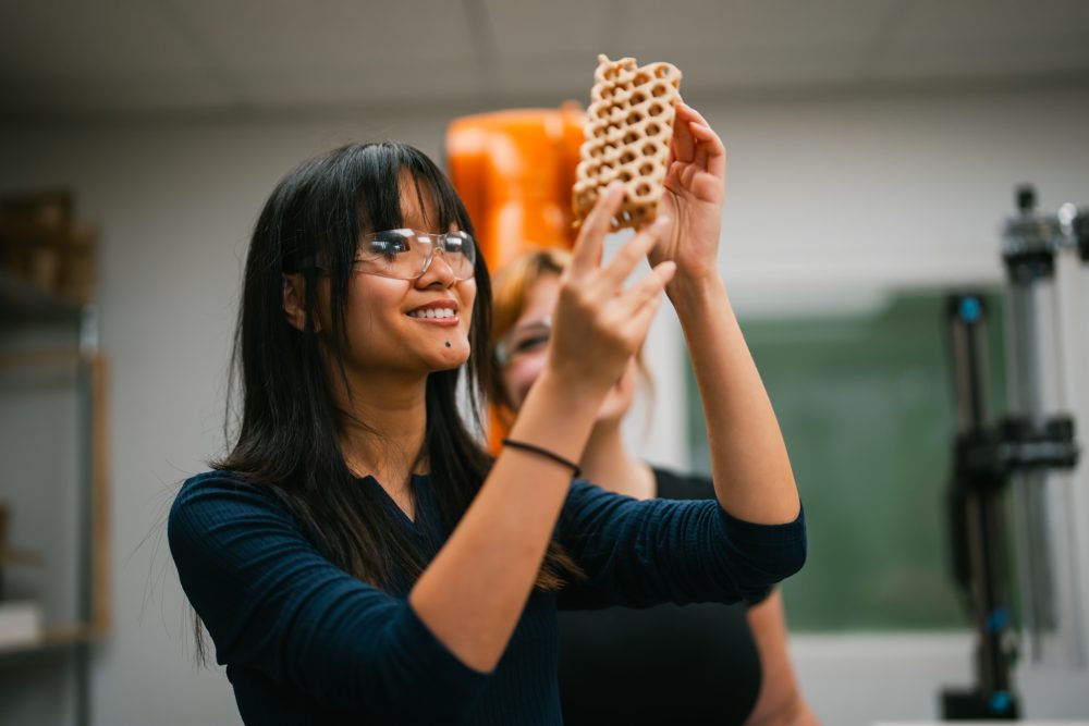 student holding model of emergent material