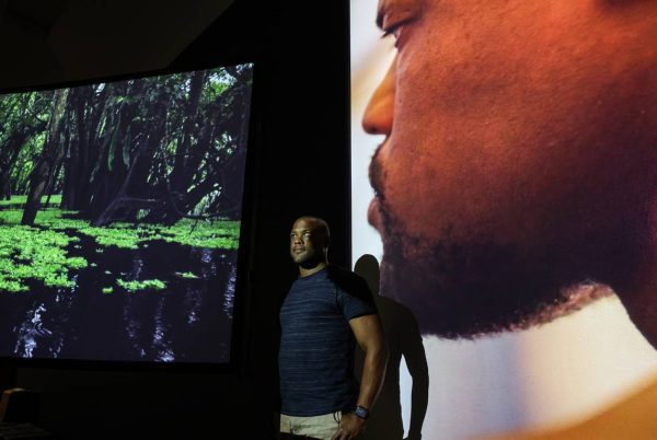 Dance alum Davian Robinson in front of a video installation at the Bechtler Museum.