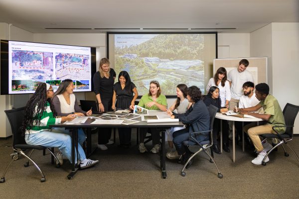12 students who worked on the Chimney Rock project, seated in groups in a classroom