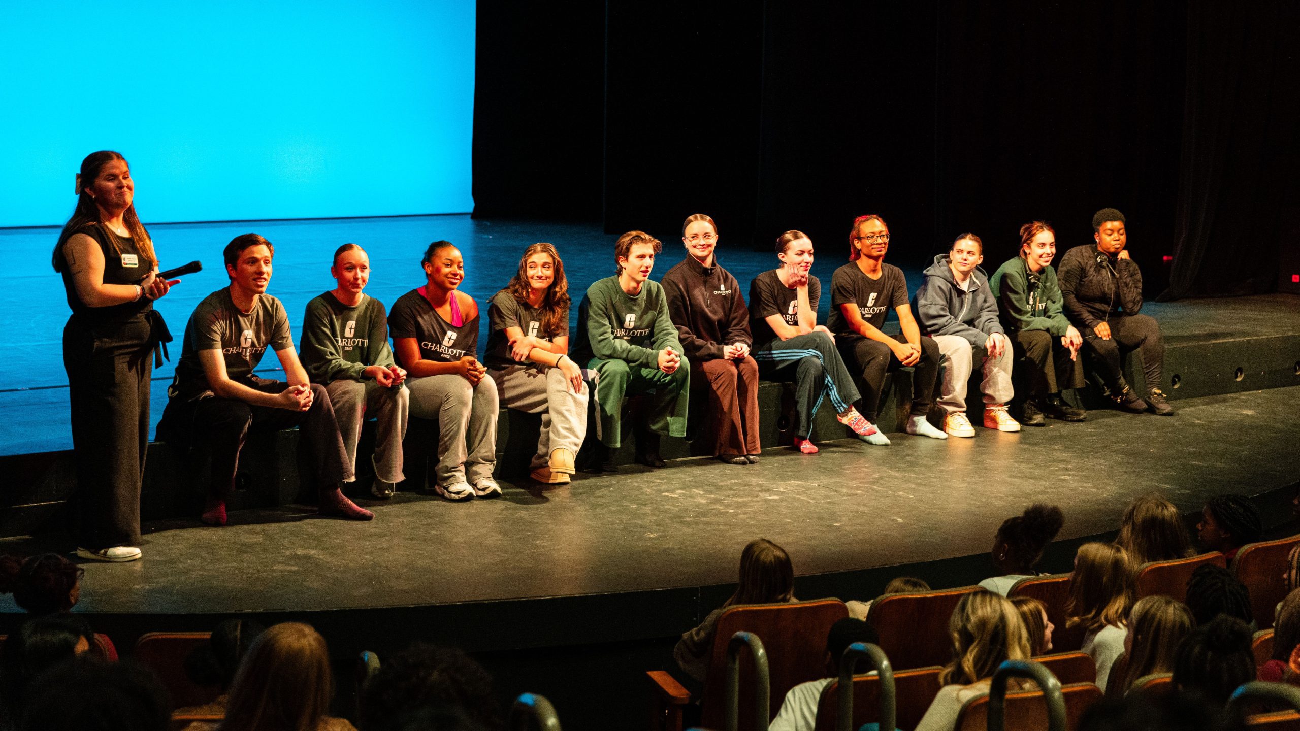 Students sit on edge of stage for Q&A
