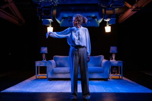 A woman character on stage in the production of the play "Girls & Boys"