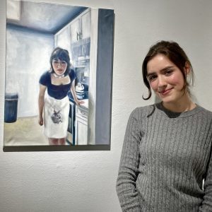 Laura Lucas with her self-portrait, "Fade to White," in Rowe Side Gallery.