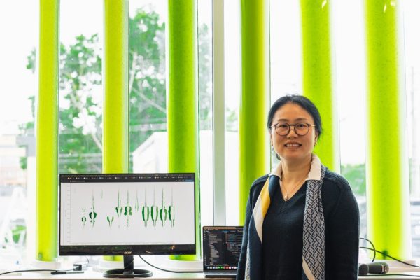 Kyoung Hee Kim stands in front of her microalgae window system.