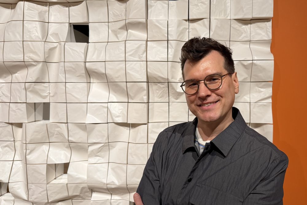 Close up of Tom Schmidt with his artwork at the Mint Museum